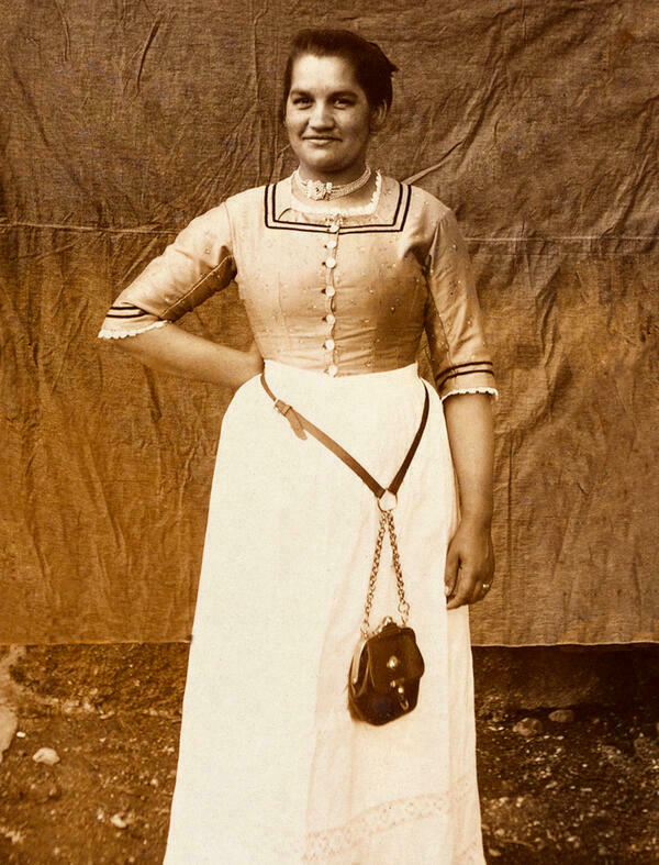 Schwarzweifotografie einer oberbayerischen Kellnerin um 1910. Am Grtel des Dirndls im Leibgewand hngt die Kellnerinnentasche.